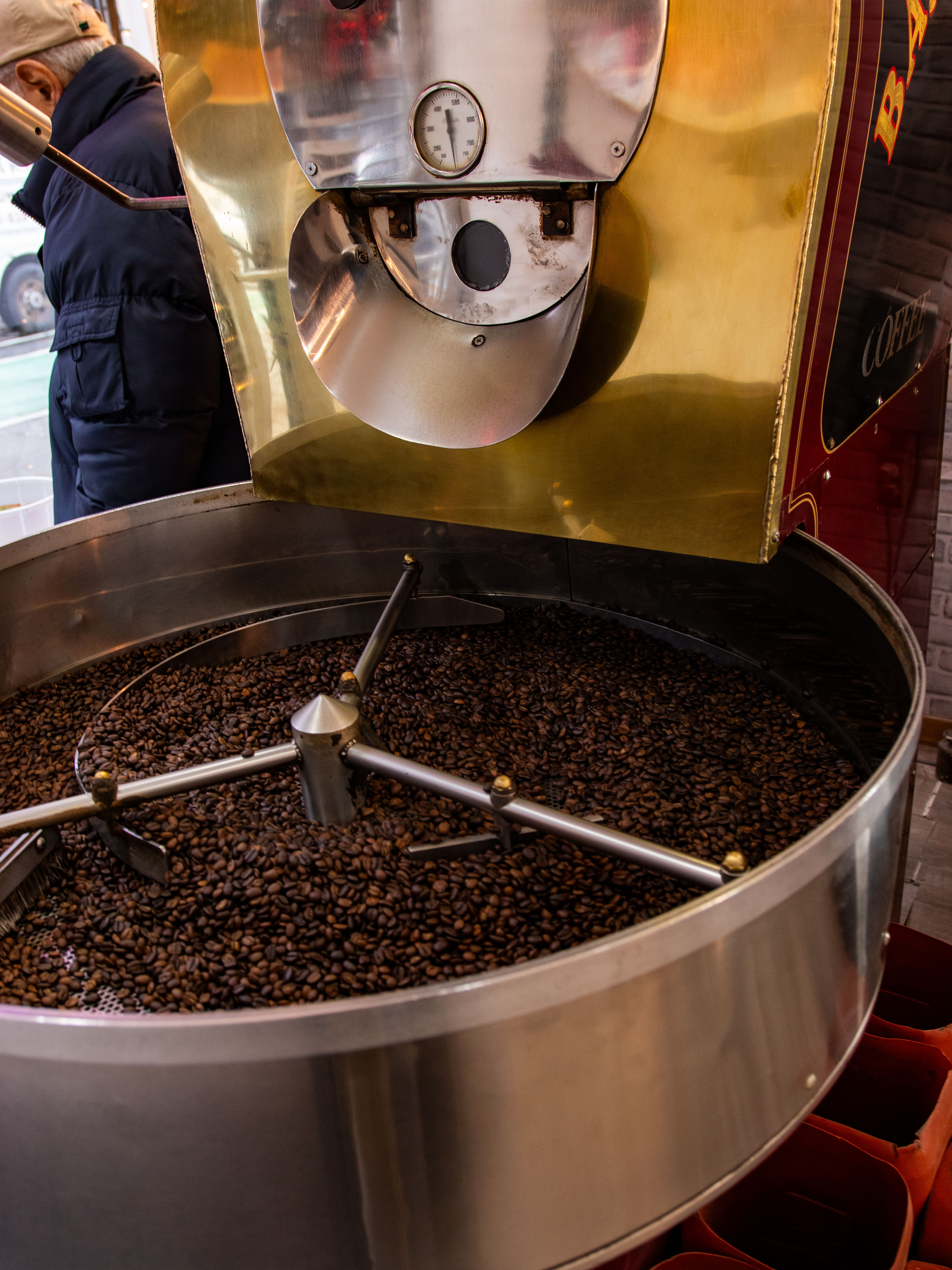 "Roasted coffee beans inside a large industrial roaster machine."